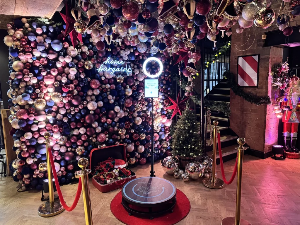360 photo booth in front of a bauble wall at a Christmas event