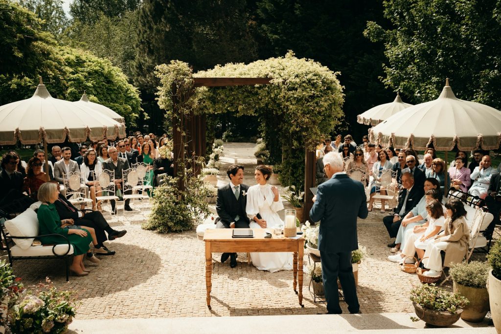 Outdoor wedding ceremony with guests seated in a garden